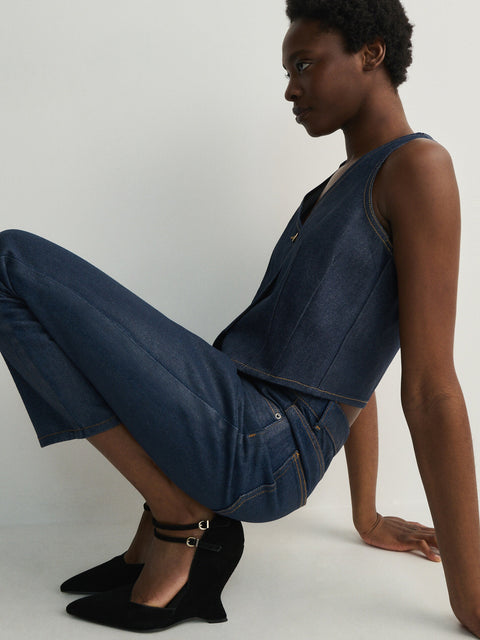 Woman wearing a denim outfit sitting on a white background