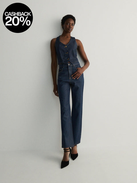 Person wearing a denim jumpsuit on a plain background with a cashback 20% badge.