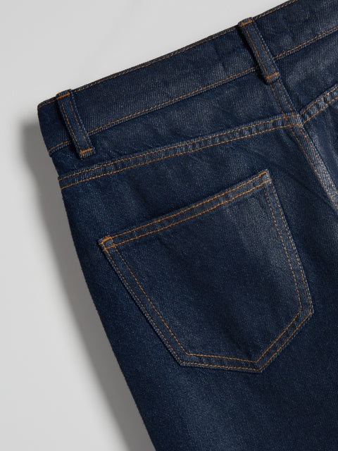 Close-up of a blue denim pocket on a plain background