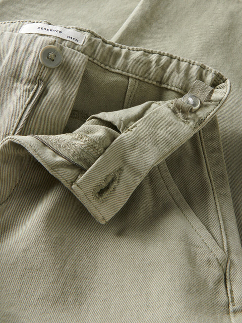 Close-up of a green jacket with button details and a 'RESERVED' tag.