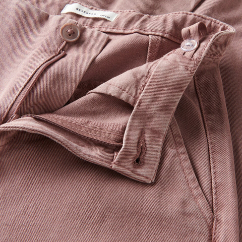 Close-up of a pink shirt with a brand label on a matching fabric background