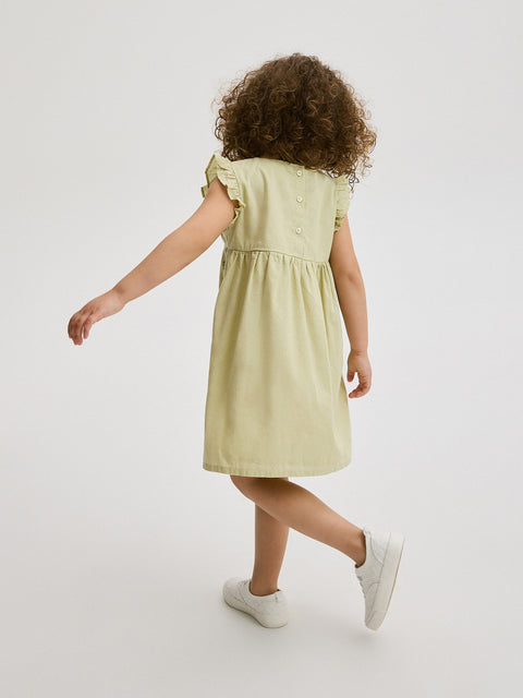 Child wearing a light green dress on a white background