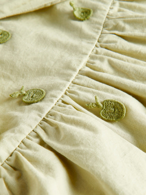Close-up of beige fabric with green embroidered patterns