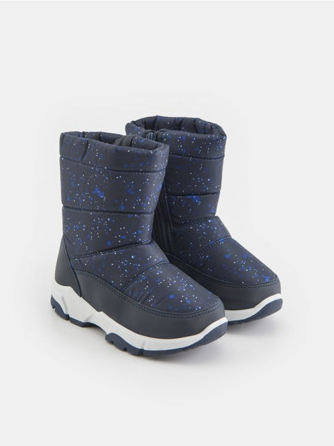 Pair of navy blue winter boots with white soles on a light gray background