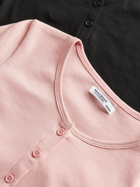 Close-up of a pink garment with a label on a black background