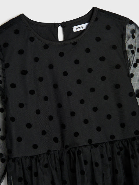 Black polka dot dress with long sleeves on a white background
