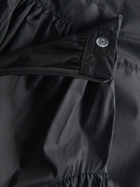 Close-up of a black skirt with a button detail