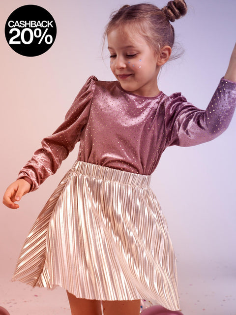 Child wearing a sparkly pink top and gold pleated skirt with a cashback 20% offer in the corner.