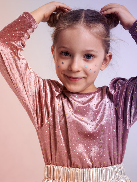 Young girl in a sparkly pink dress with a plain background