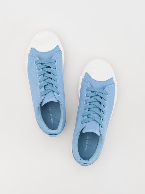 Pair of blue sneakers on a light gray background