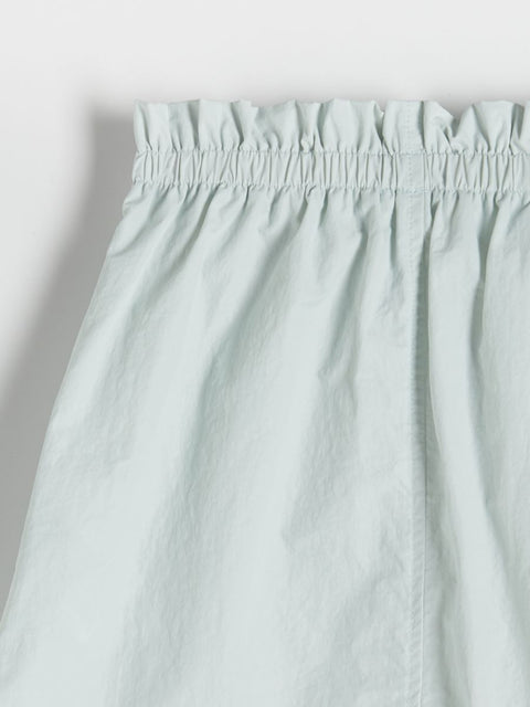 Light blue pants with an elastic waistband on a light gray background