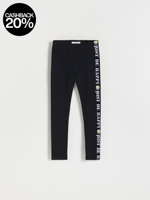 Black leggings with motivational text and colorful designs on a light gray background