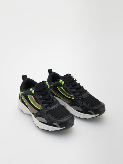 Black and gray athletic shoes with green accents on a white background