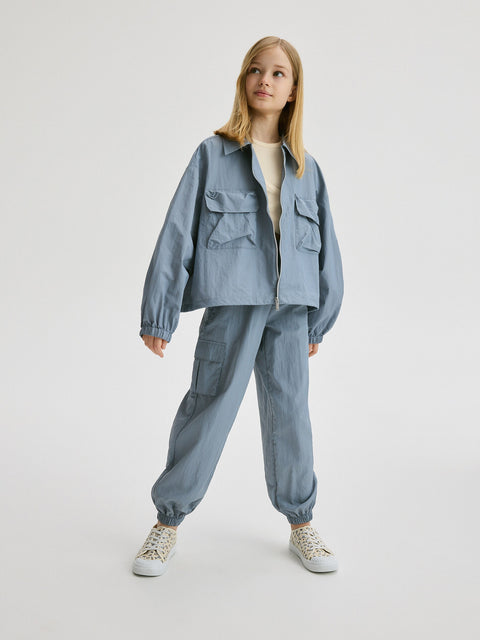 Person wearing a blue outfit with a jacket and pants on a white background