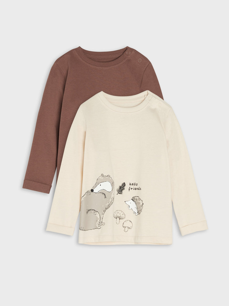 Two children's shirts, one brown and one beige with a graphic design, on a light gray background.