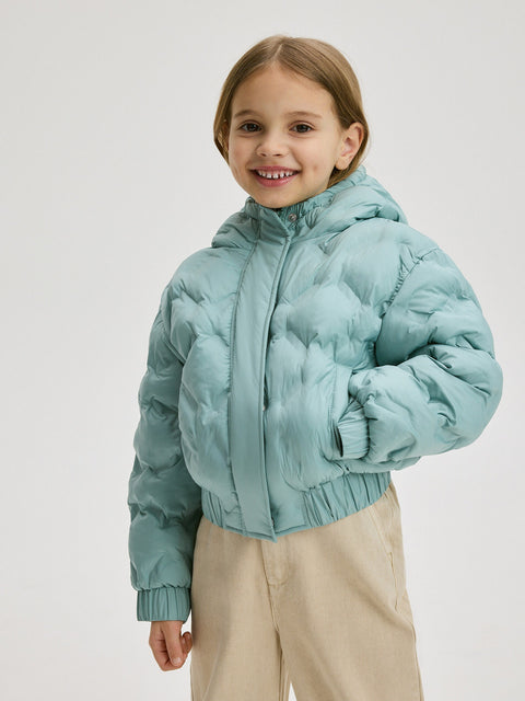 Child wearing a light blue puffer jacket on a white background