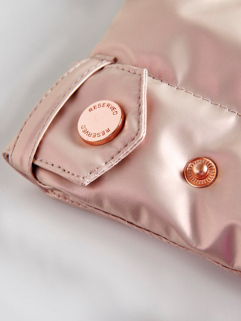 Close-up of a pink satin Jacket with 'RESERVED' branding on a light gray background
