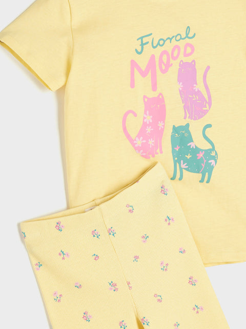Yellow t-shirt with colorful cat design and 'Floral Mood' text on a matching fabric background.