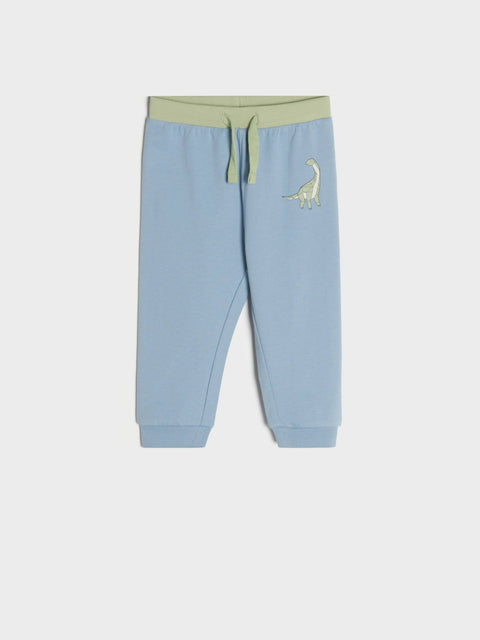Light blue children's sweatpants with a green dinosaur design on a white background