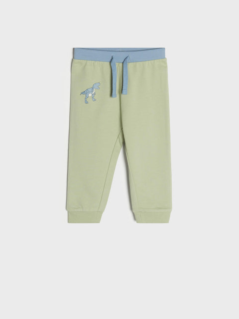 Light green jogger pants with blue waistband and dinosaur embroidery on a white background