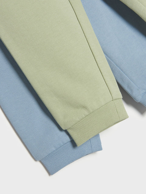 Stack of pastel green and blue pants on a white background