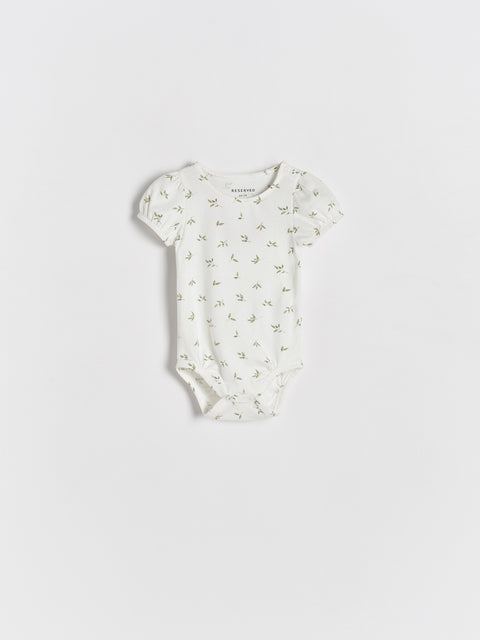 White baby bodysuit with floral pattern on a light gray background