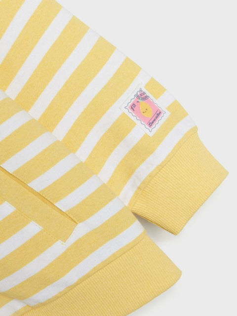 Yellow and white striped sweater with a brand label on a light gray background