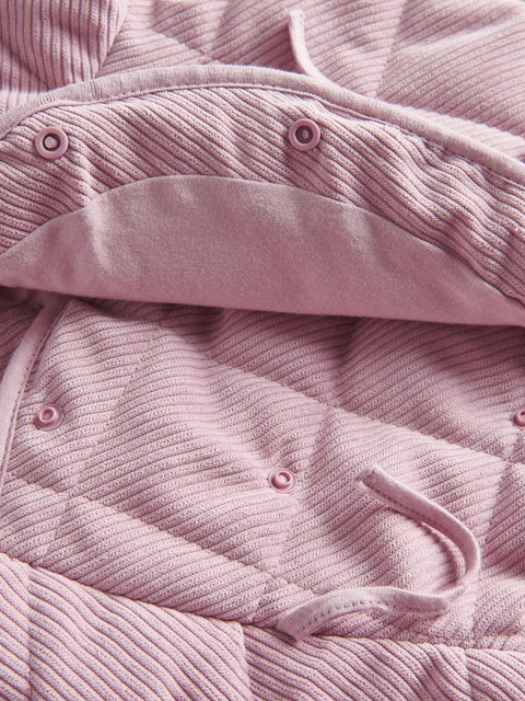 Close-up of a pink textured fabric with buttons