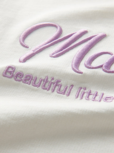 Embroidered text on a white fabric with a soft focus effect