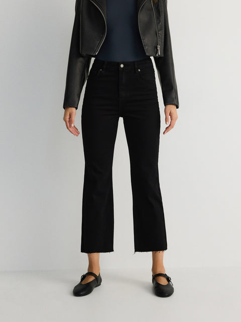 Person wearing black pants and a black leather jacket on a white background