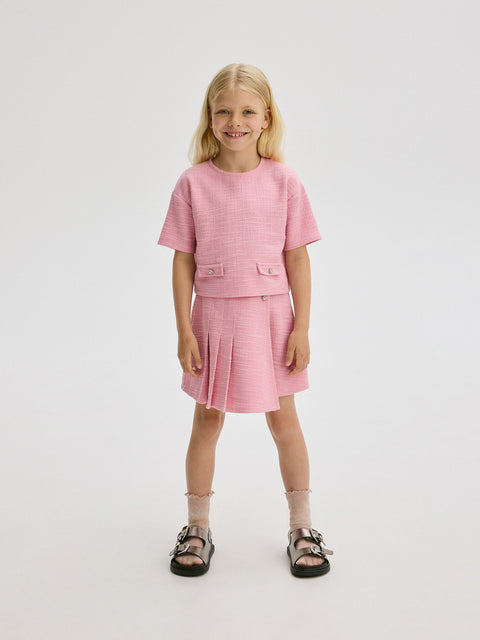 Young girl wearing a pink outfit on a white background
