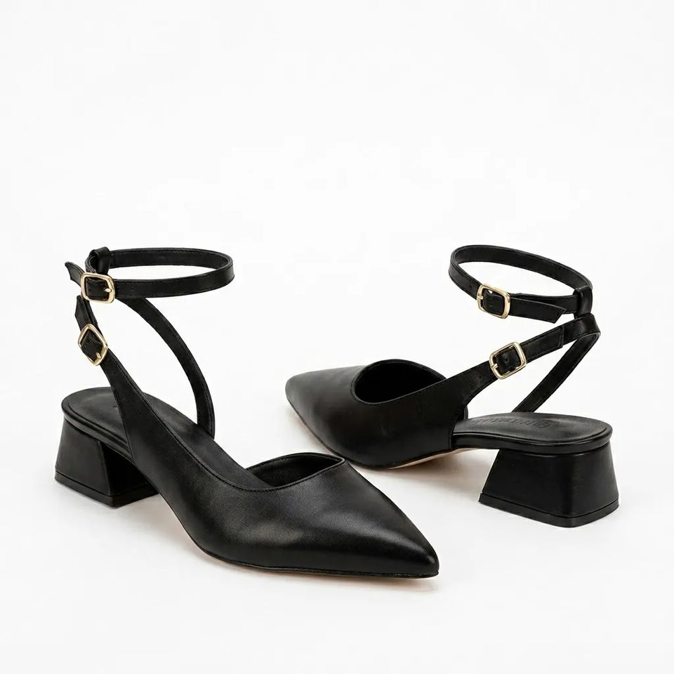 A pair of black pointed-toe slingback heels with block heels and ankle straps featuring gold-tone buckle details, shown on a clean white background.