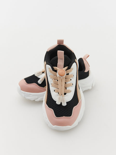 Pair of pink and black sneakers on a light gray background