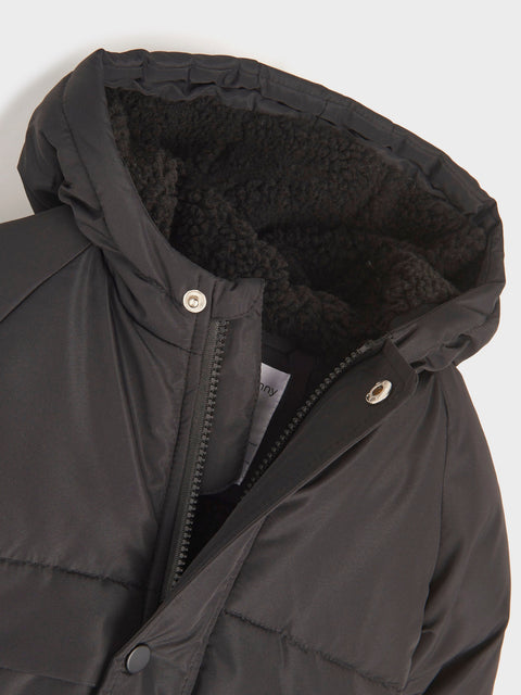 Close-up of a dark gray winter coat with black fur lining on a light gray background