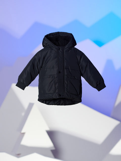 Black puffer jacket on a white platform with a blue geometric background