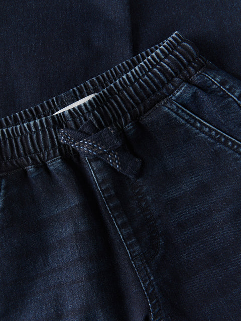 Close-up of dark blue pants with a drawstring waistband.