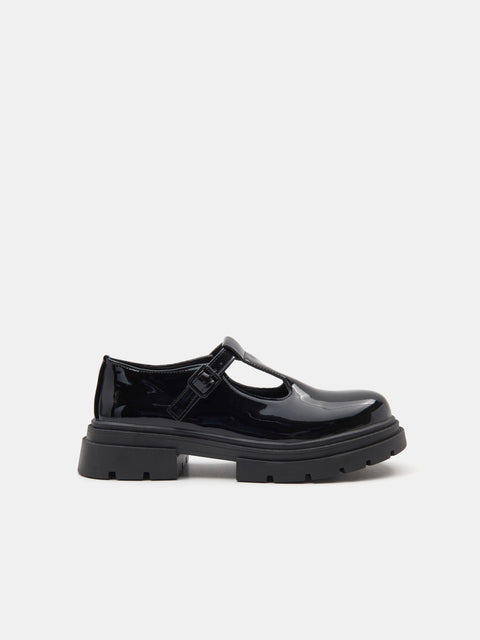Black patent leather shoe on a white background