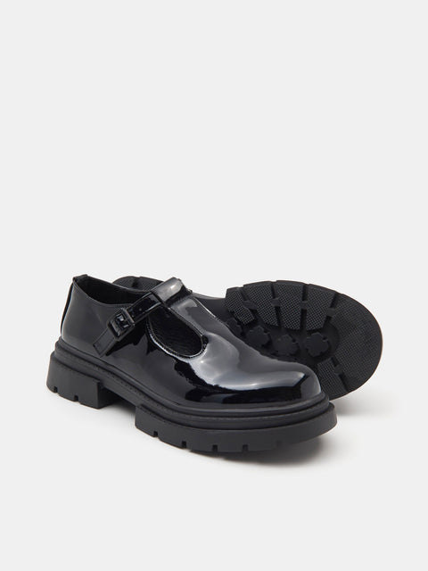 Black shiny shoes with a strap on a white background