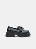Black loafers with a decorative element on a white background