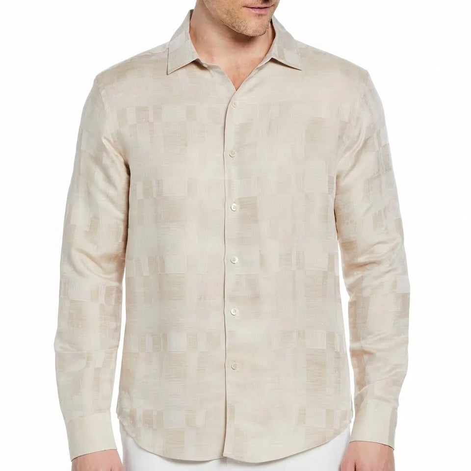 A man wearing a light beige long-sleeve button-up shirt with a subtle tonal geometric pattern, shown from the neck down against a plain white background.