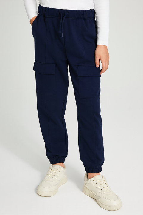 Navy cargo jogger pants worn by a person on a white background