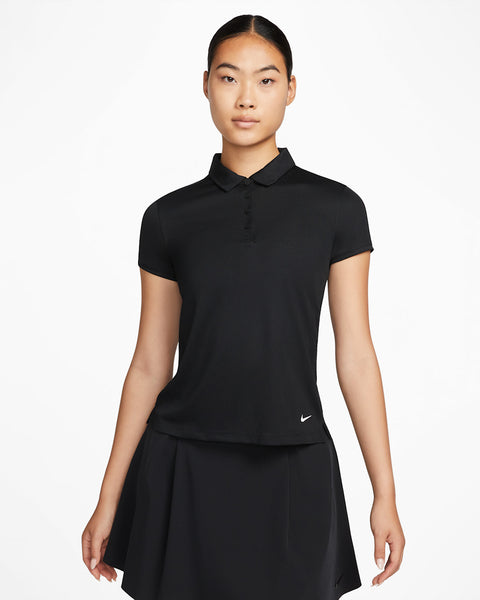 Woman wearing a black Nike polo shirt and skirt on a white background