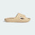 A single beige slip-on slide sandal with a thick, sculpted foam sole and a cutout strap, shown in profile against a light gray background.