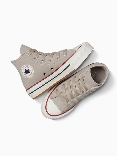 Pair of beige Converse sneakers on a white background