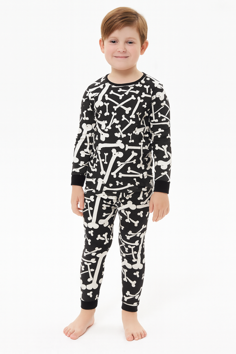 Child wearing black pajamas with white bone pattern on a white background