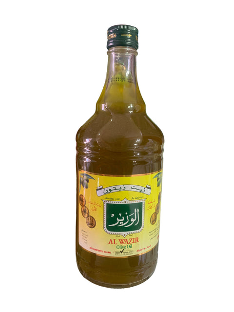 Hand holding a bottle with a yellow label featuring branding, against a cluttered background.