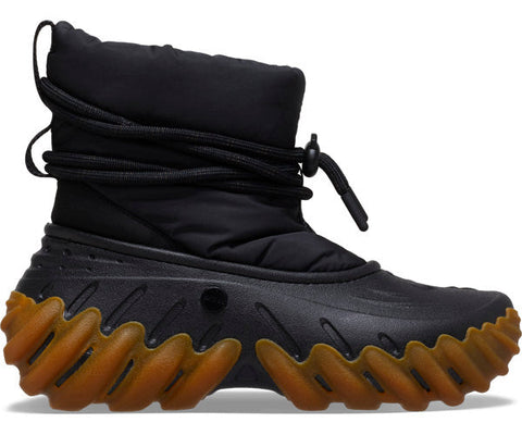 Black winter boot with brown sole on a white background