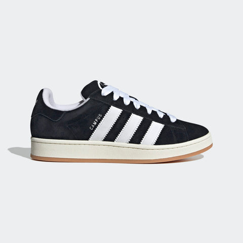 Black Adidas sneaker with white stripes on a light gray background