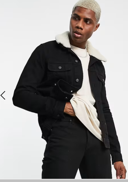 A man wearing a black denim jacket with a detachable borg collar, zippered front, and a beige-colored hood.