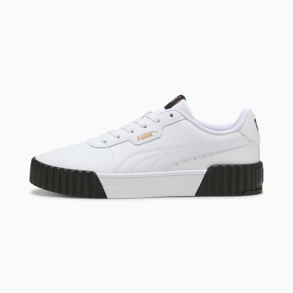 A white Puma platform sneaker with a chunky black sole and a gold Puma logo on the side, shown against a plain white background.